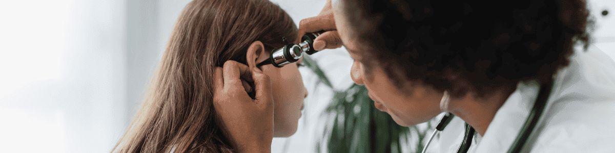 doctor checking girl's ear for an ear infection