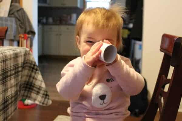 little girl looking through a toliet paper tube