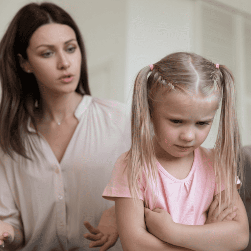 little girl upset facing away from her mom who is trying to talk to her