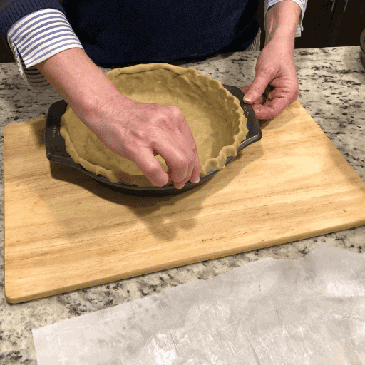 gluten and dairy free pie crust dough being shaped in a pie pan